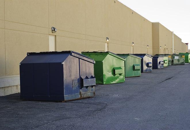 construction workers throw waste into a dumpster behind a building in Hallandale Beach, FL